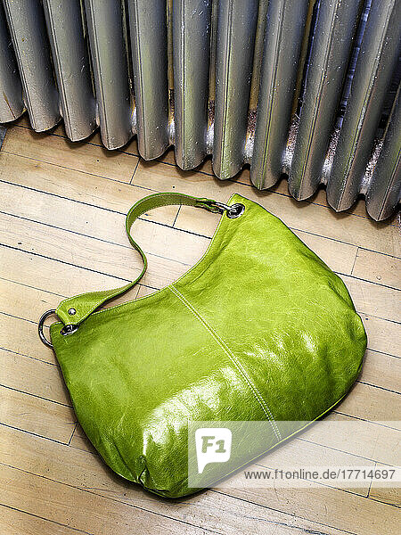 Übersicht über die grüne Handtasche der Frau auf dem Hartholzboden