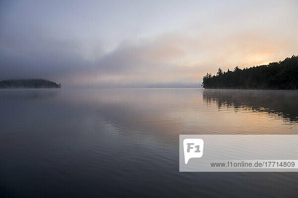 Sonnenaufgang über einem See an einem nebligen Morgen  Algonquin Park  Ontario