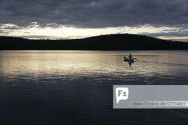 Frau paddelt alleine bei Sonnenuntergang  Algonquin Park  Ontario