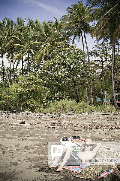Surfer Lounges On The Beach; Dominical  Costa Rica
