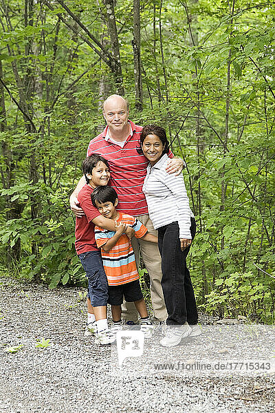 Kanadisch-südasiatische Familie in einer Waldstraße  Ontario