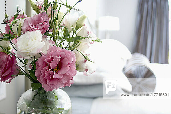 Rosa und weiße Lisianthusblüten auf dem Nachttisch
