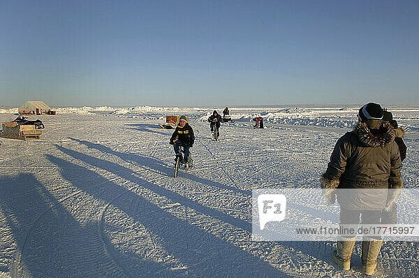 Kinder fahren mit dem Fahrrad auf dem Meereis  Cambridge Bay  Nunavut