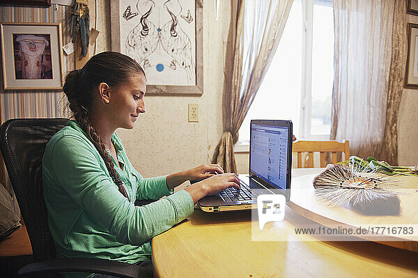 Einheimisches amerikanisches Teenager-Mädchen  das zu Hause einen Laptop-Computer benutzt; Rossburn  Manitoba  Kanada