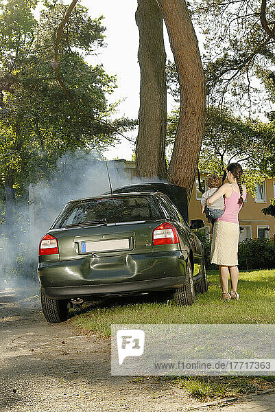 Auto verunglückt und raucht auf Baum mit Mutter und Kind zu beobachten