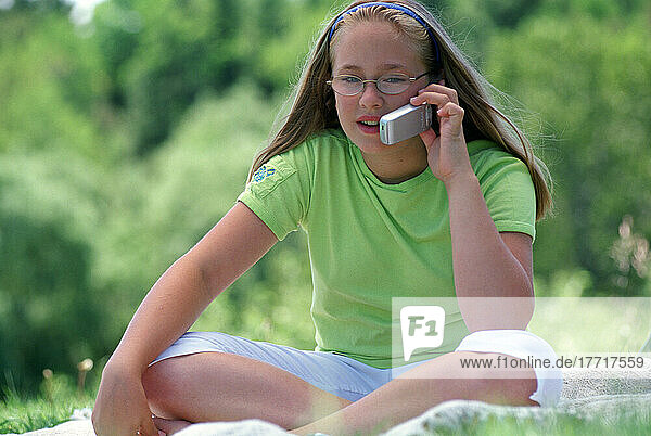 Mädchen im Gespräch auf Handy im Freien