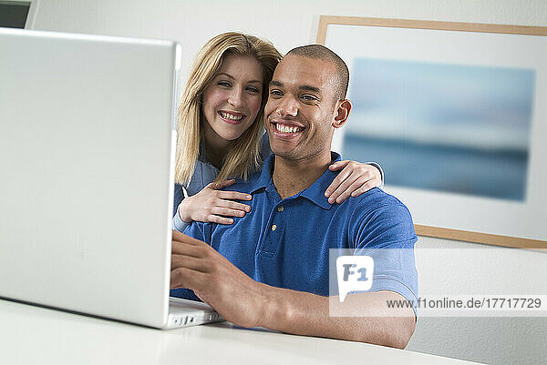 Junges Paar schaut auf den Computer