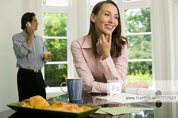 Frau mit Zeitschrift  Mann mit Handy in der Küche