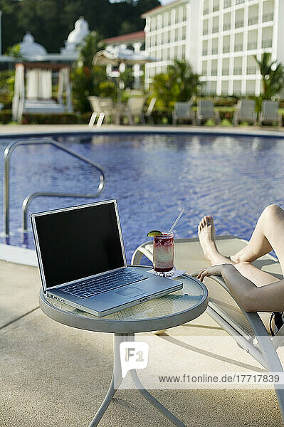 Frau sonnt sich an einem Pool mit einem Laptop  Panama-Stadt  Panama