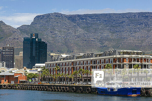 The Cape Grace Hotel with office buildings and Table Mountain in the background along the harbor at the Victoria and Alfred Waterfront in Cape Town; Cape Town  Western Cape  South Africa