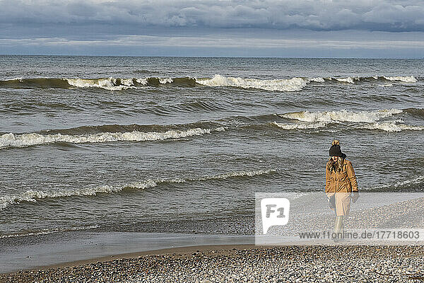 Frau  die am Ufer des Huron-Sees in Ontario spazieren geht; Grand Bend  Ontario  Kanada