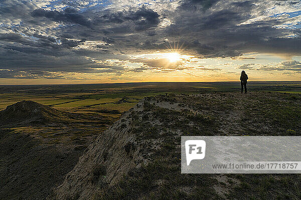 Frau  die den Sonnenuntergang über den Prärien von Saskatchewan beobachtet; Val Marie  Saskatchewan  Kanada