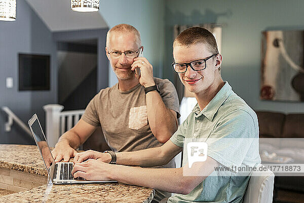 Vater und Sohn nutzen zu Hause gemeinsam Technologie; Edmonton  Alberta  Kanada
