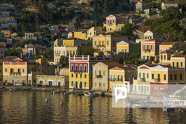 Warm sunlight on the colorful buildings along the waterfront in Gialos Harbor  Symi (Simi) Island; Dodecanese Island Group  Greece