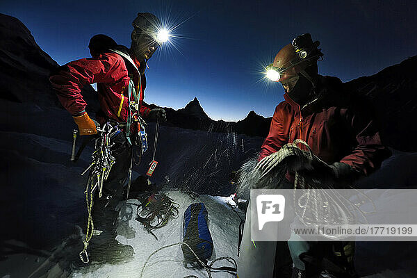 British cave explorers packing the climbing equipment before the cold affects their hands and feet.