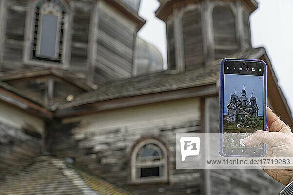 Tourist fotografiert eine alte Kirche im ländlichen Saskatchewan mit einem Smartphone; Maryville  Saskatchewan  Kanada
