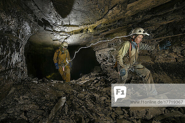 Two explorers climb along a rocky breakdown passage in Veryovkina cave. During the flood pulse that came down through the cave a week after this photograph was taken  all of this completley filled up with water  right up to the roof; Gagra  Caucasus Mountains  Abkhazia