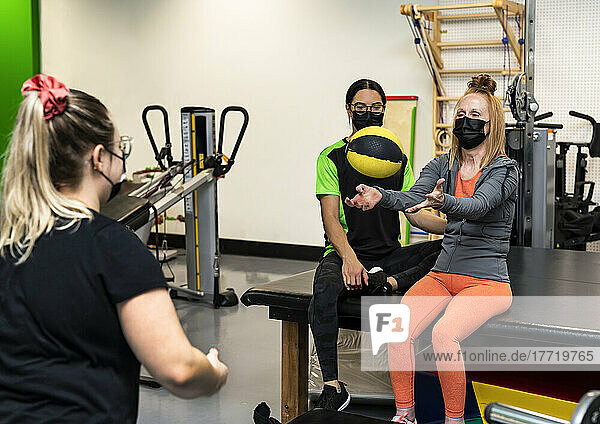 Eine querschnittsgelähmte Frau wirft während ihres Trainings mit ihren Trainern einen Medizinball: Edmonton  Alberta  Kanada