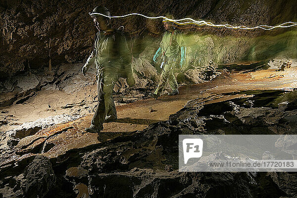 Zwei Forscher gehen über eine schmale Brücke aus Kalzitkristallen in der Veryovkina-Höhle. Während des Hochwassers  das die Höhle eine Woche nach der Aufnahme dieses Fotos überflutete  füllte sich die gesamte Höhle bis zur Decke mit Wasser; Gagra  Kaukasus  Abchasien