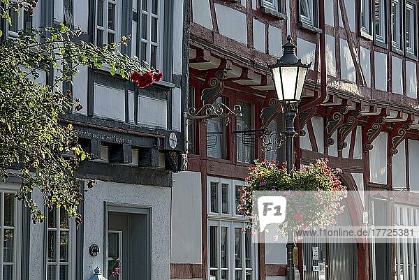 Idylle  Straßenlaterne  geschmückt mit Geranien  Kletterrosen vor historischen Fachwerkhäusern  Oberstadt  Altstadt  Lich  Wetterau  Hessen  Deutschland  Europa