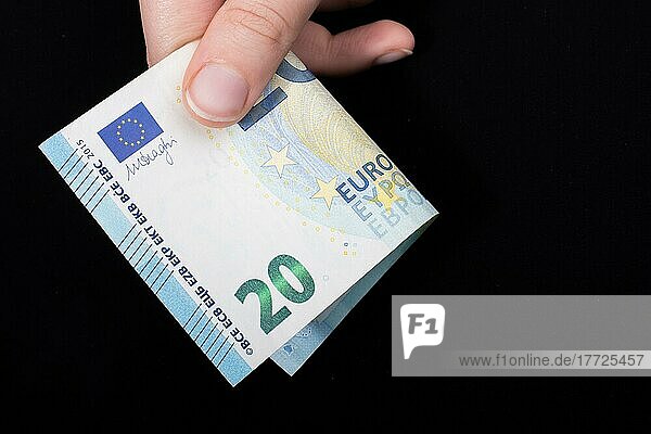 Hand hält 100 Euro Geld Bargeld vorschwarzem Hintergrund