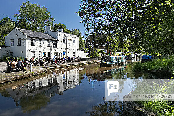 A canal narrowboat approaches the Shroppie Fly Inn  Shropshire Union Canal  Audlem  Cheshire  England  United Kingdom  Europe