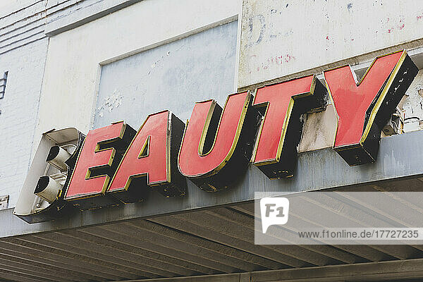 Altes BEAUTY-Schild vor einem verlassenen Kaufhaus  rote Schrift.