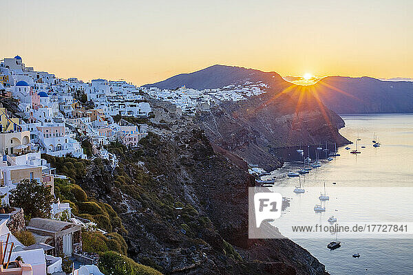 Sunrise over coast of Oia and typical white buildings  Santorini  Cyclades  Greek Islands  Greece  Europe