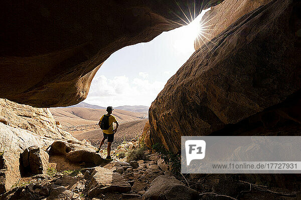 Man enjoying the view standing inside the sandstone canyons  Barranco de las Penitas  Fuerteventura  Canary Islands  Spain  Atlantic  Europe