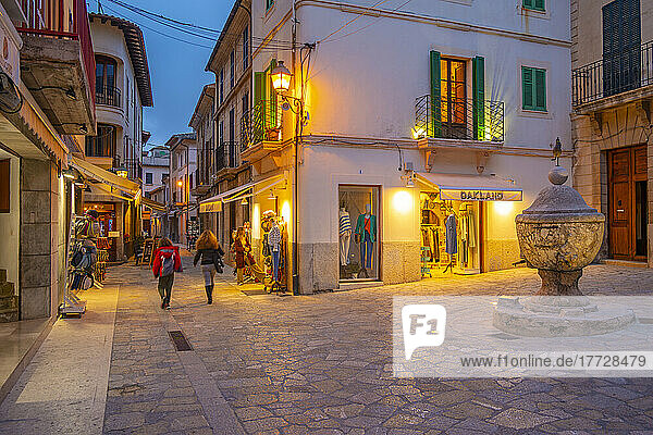 View of shops in narrow street in the old town of Pollenca at dusk  Pollenca  Majorca  Balearic Islands  Spain  Mediterranean  Europe