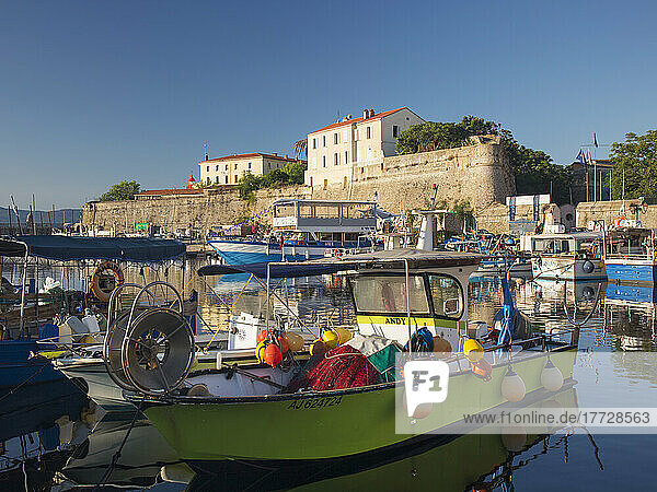 View across tranquil harbour to the citadel  sunrise  typical fishing boat in foreground  Ajaccio  Corse-du-Sud  Corsica  France  Mediterranean  Europe