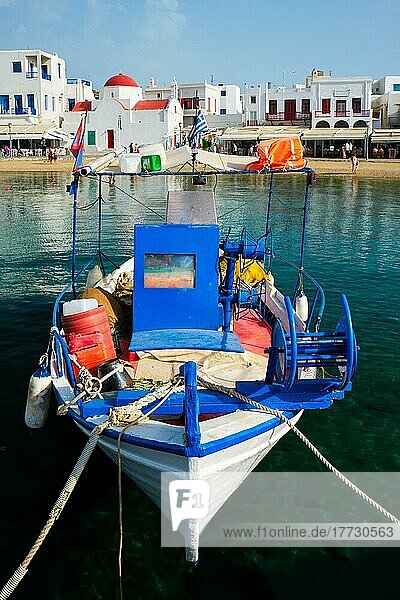 Blaues Fischerboot im Hafen der Stadt Chora auf der Insel Mykonos mit orthodoxer Kirche im Hintergrund  Griechenland  Europa