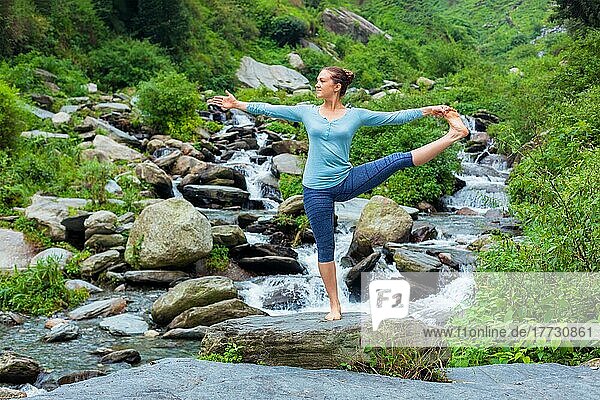 Yoga im Freien  Frau  die Ashtanga Vinyasa Yoga Balance Asana Utthita Hasta Padangushthasana  Extended Hand-To-Big-Toe Pose Position Haltung im Freien am Wasserfall
