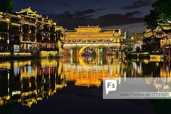 Chinese tourist attraction destination  Feng Huang Ancient Town (Phoenix Ancient Town) on Tuo Jiang River illuminated at night. Hunan Province  China  Asia