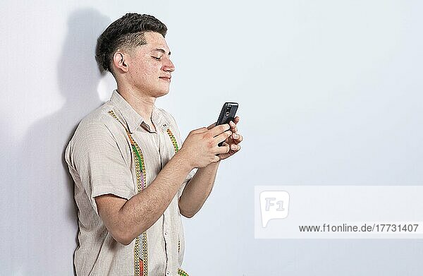 Handsome guy happy with his cell phone on isolated backgrounds  young latin man happy with his cell phone isolated  man on white background texting with his cell phone