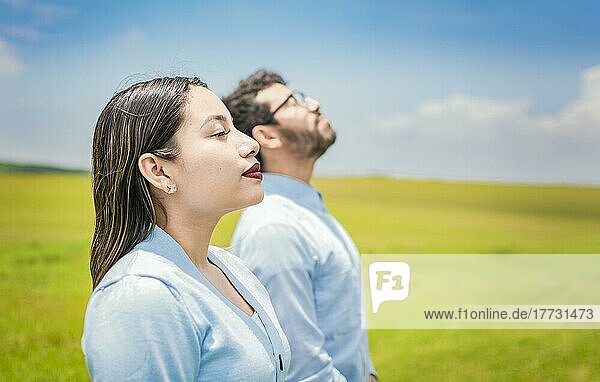 Young couple breathing fresh air in the field  Concept of Young couple breathing fresh air with positive attitude  Two people breathing fresh air in the field