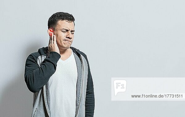Person mit Ohrenschmerzen  auf isoliertem Hintergrund  Leidender Mann massiert sein Ohr isoliert  Eine Person mit Otitis und Tinnitus