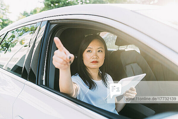 Businesswoman with tablet PC sitting in car