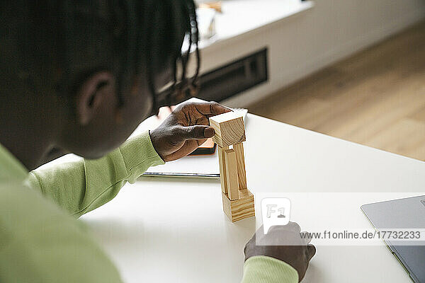 Student examining wooden block at home