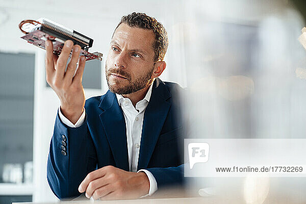 Businessman looking at heating module in office