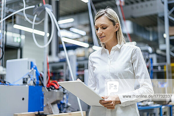 Businesswoman using digital tablet in factory