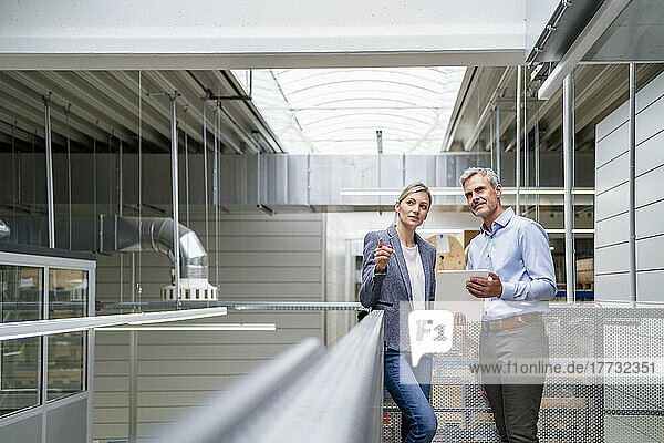 Businessman and businesswoman talking in factory