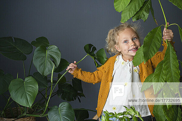 Girl having fun with houseplants at home