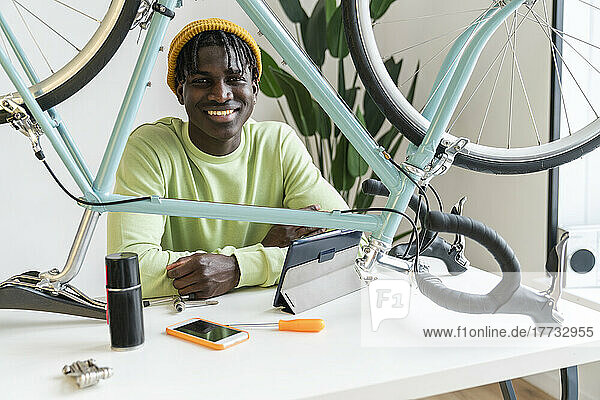 Smiling vlogger with bicycle on table at home