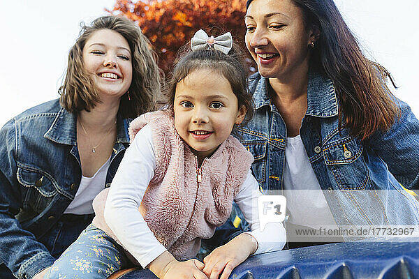 Cute girl enjoying with her sister and mother in park