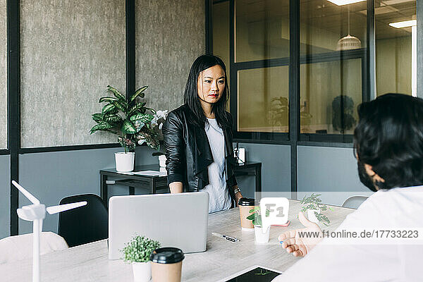 Businesswoman discussing with colleague in meeting at office