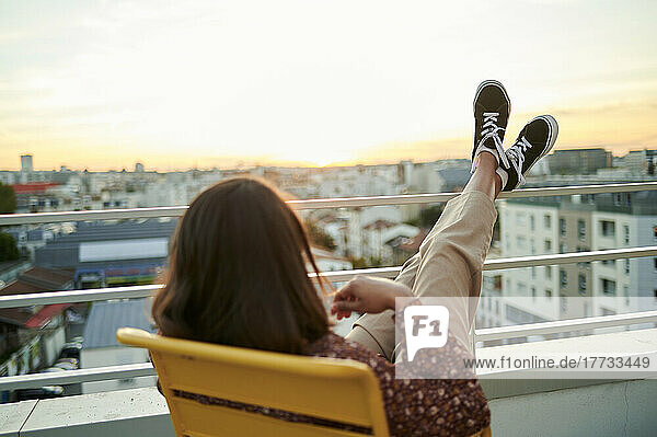 Woman relaxing in balcony at sunset