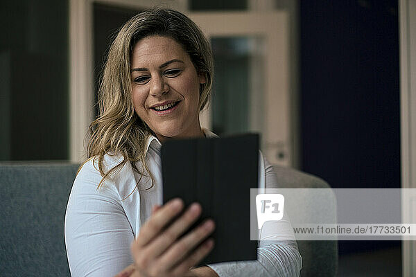 Smiling businesswoman taking selfie through tablet PC in office