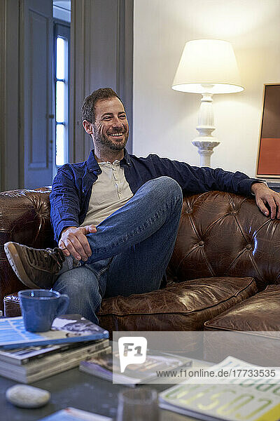 Smiling man sitting on sofa in living room