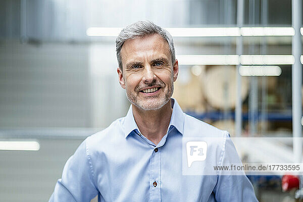 Portrait of confident mature businessman in factory
